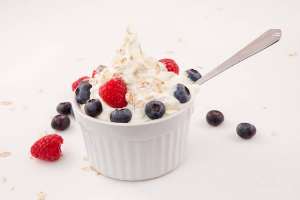 istock White jar of berries and whipped cream with spoon 826924640