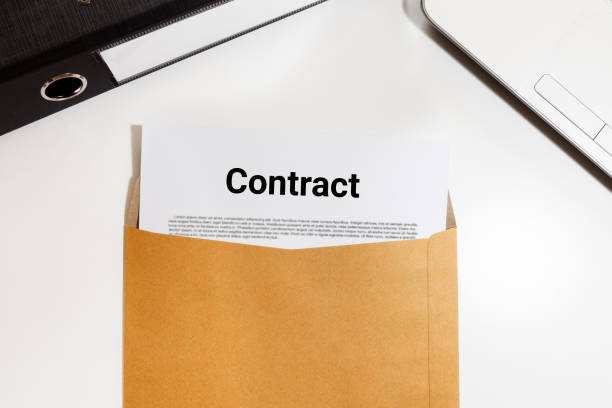 istock Contract document in envelope with file and notebook on desk - business concept 826925488