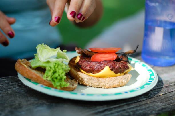istock Woman's hands above a plate with a burger. 826927828