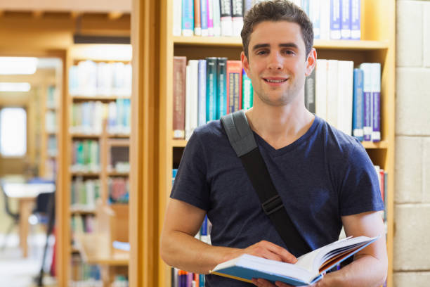 istock Man standing at a bookshelf holding a book 826928296