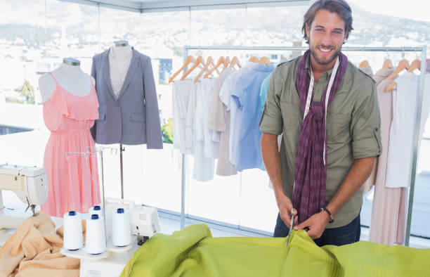 istock Handsome fashion designer cutting textile 826929692