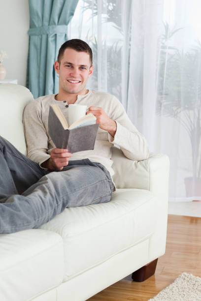 istock Portrait of a happy man reading a book 826938916