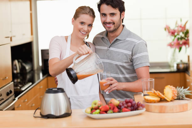 istock Young couple making fruits juice 826940190