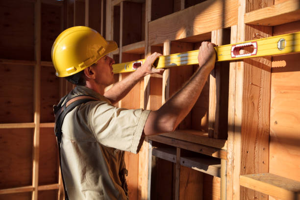 Home Building - Measuring Wall Carpenter building a home at construction site.  Measuring wall spirit level stock pictures, royalty-free photos & images