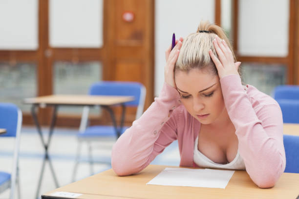 istock Woman looking at exam paper anxiously 826947322