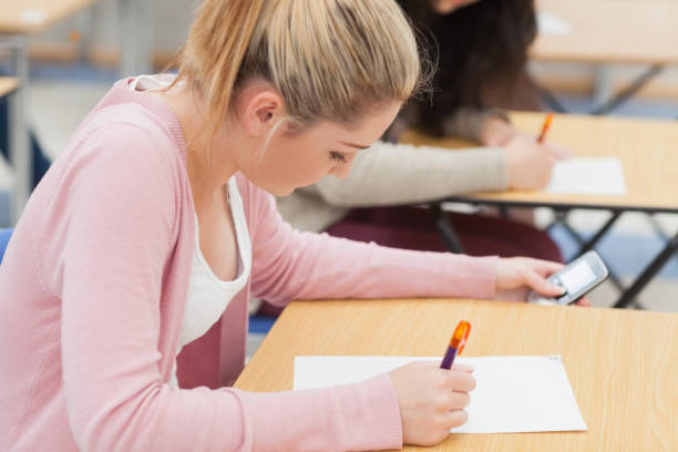 istock Girl is checking phone during exam 826947402