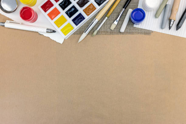 workplace of the artist: watercolor palette, paints, paintbrushes, colored chalks