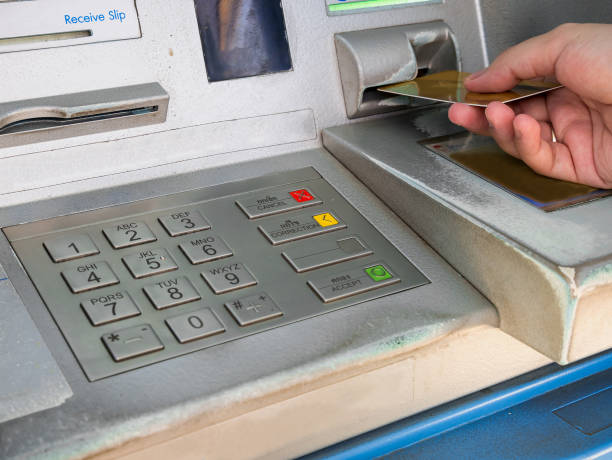 istock female hand inserting ATM card into ATM bank machine 826952238