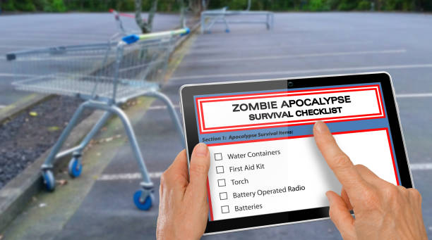 Hand completing Zombie Apocalypse survival checklist on a computer tablet stock photo