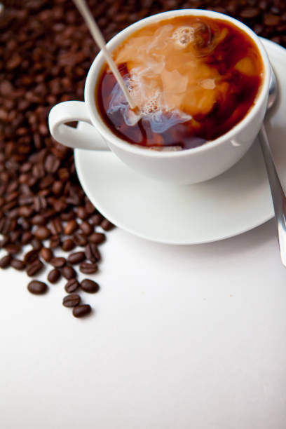 Black coffee and milk with beans against a white background