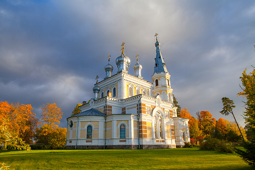 Sunset landscape of beautiful Orthodox church on the meadow, fall time. Stameriena, Latvia.