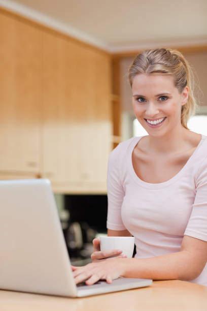 istock Portrait of a woman using a laptop while drinking coffee 826962560