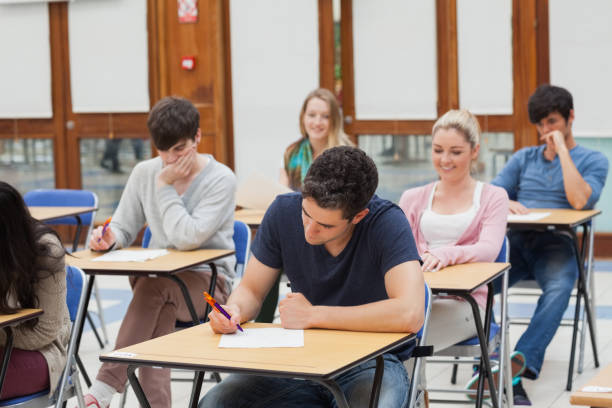 istock Students sitting at the exam room writing 826963802