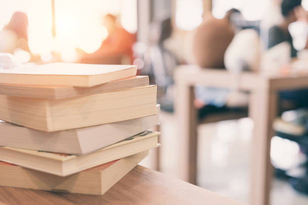 istock books stack on the library table. At the time of university student exams in selective focus. 826964024
