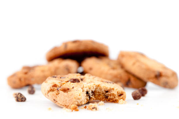Halfeaten cookie in front of a stack of cookies against a white background