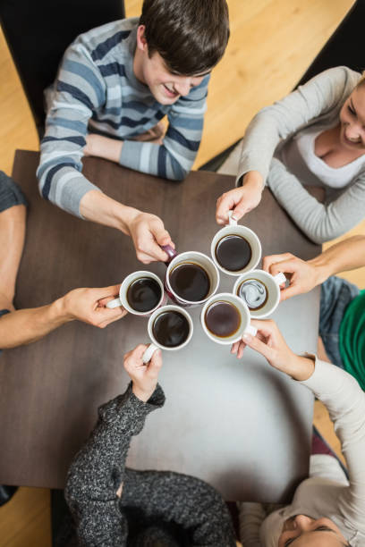 istock People holding up cups of coffee 826966928