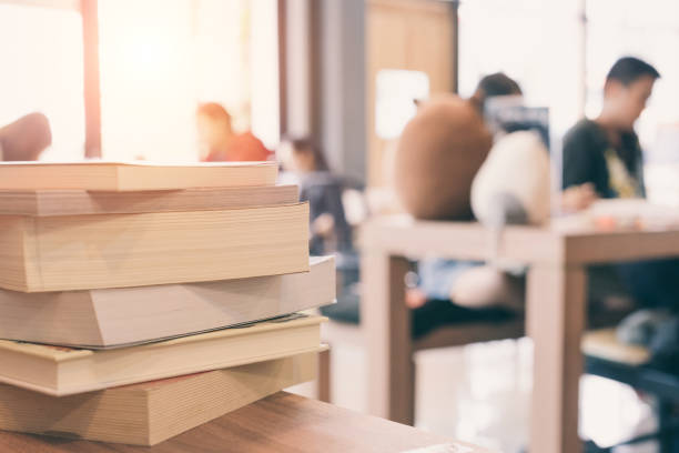 istock books stack on the library table. At the time of university student exams in selective focus. 826967126