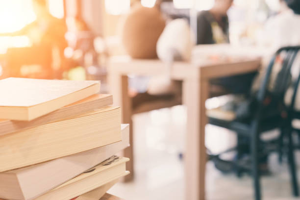 istock books stack on the library table. At the time of university student exams in selective focus. 826967162