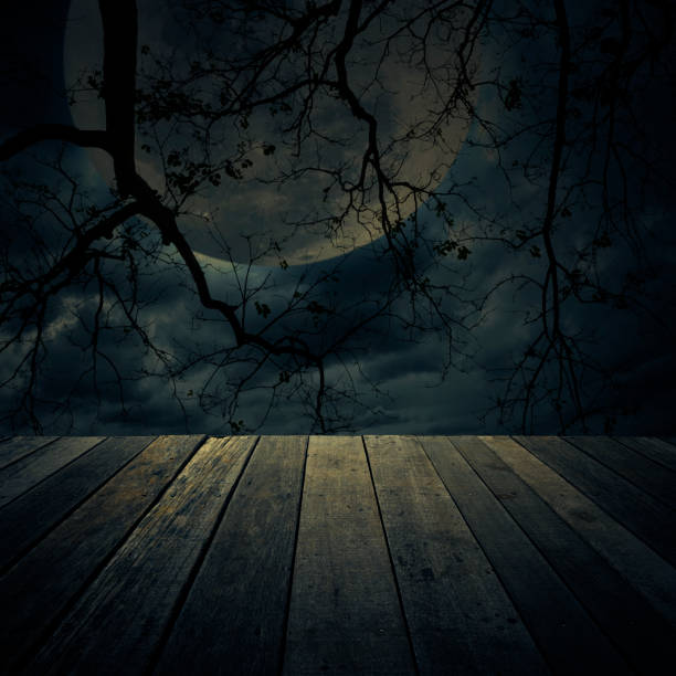 istock Old wooden table over dead tree, Halloween background 826967902