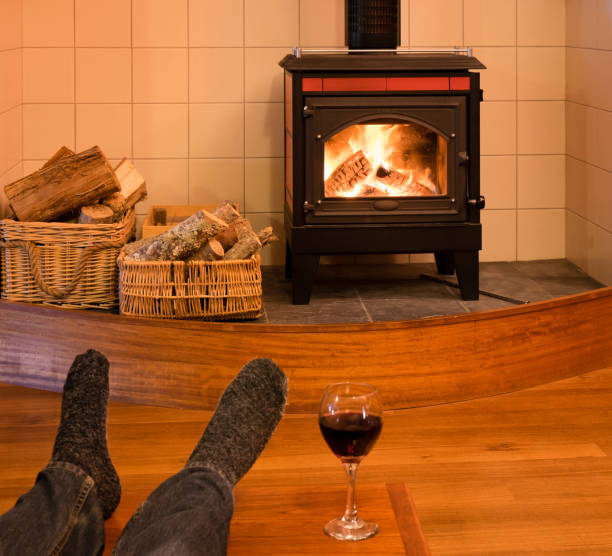 istock Feet of a single man relaxing by fire with wine 826970720