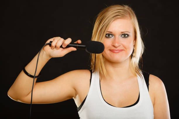 istock Blonde woman singing to microphone 826974758