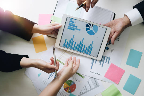 istock Business team hands at working with financial plan, meeting, discussion, brainstrom with tablet on office desk, Top view shot. 826978090