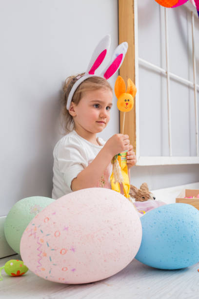 istock Beautiful young girl playing with Easter eggs and a bunny doll 826986046