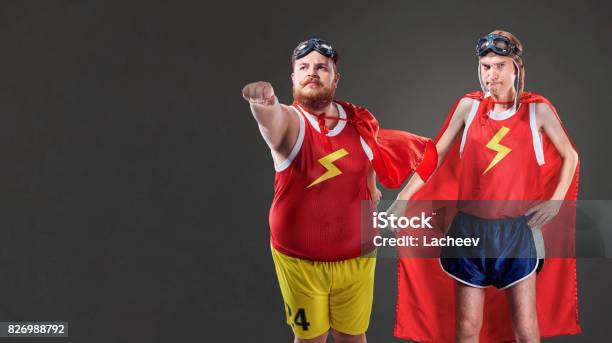 Two Funny Men In Suits Of Superheroes Thin And Fat People Stock Photo -  Download Image Now - iStock