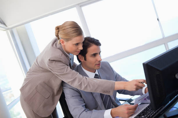 istock Manager pointing at something to her secretary on a computer 826989208