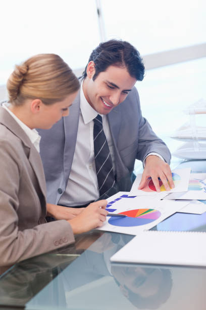 istock Portrait of smiling business people studying statistics 826989484