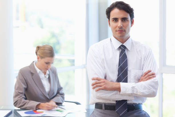 istock Businessman posing while his colleague is working 826989744