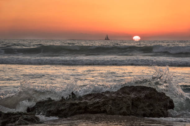 waves crashing at sunset in israel - sailboat sunset tel aviv sea imagens e fotografias de stock