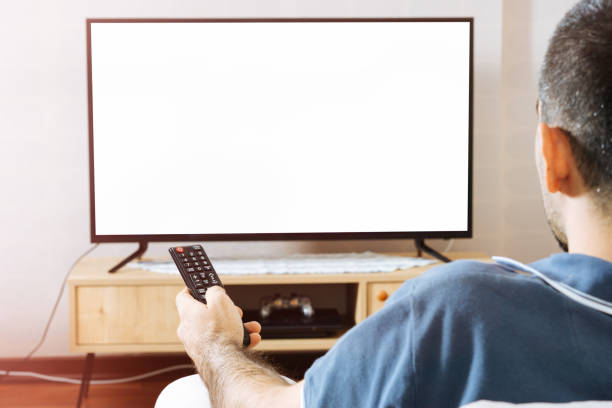 człowiek siedzi w kanapie oglądając telewizję - television flat screen plasma high definition television zdjęcia i obrazy z banku zdjęć