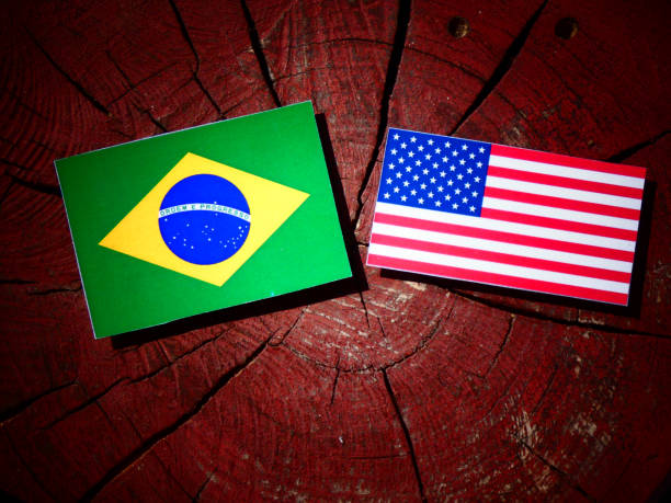 istock Brazilian flag with USA flag on a tree stump isolated 827003416
