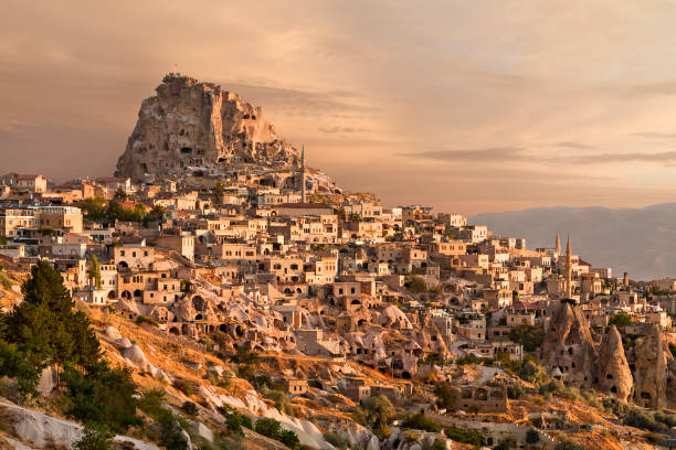 Uchisar town, in Cappadocia, Turkey. Houses and rock formations in the town of Uchisar, at the sunrise in Cappadocia, Turkey. uchisar stock pictures, royalty-free photos & images
