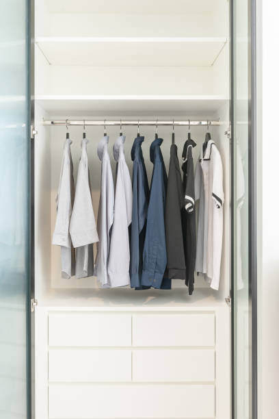 istock clothes hanging on rail in wooden white wardrobe 827015374