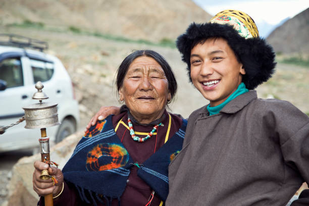istock Young boy with grandmother holding prayer wheel 827017872