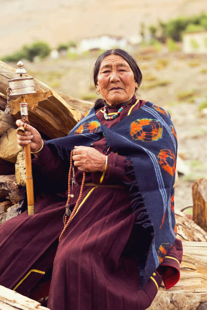 istock Old woman holding prayer wheel and beads 827021934