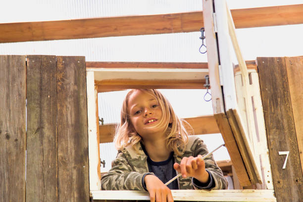 istock Hut window with young blond boy looking out. 827022624