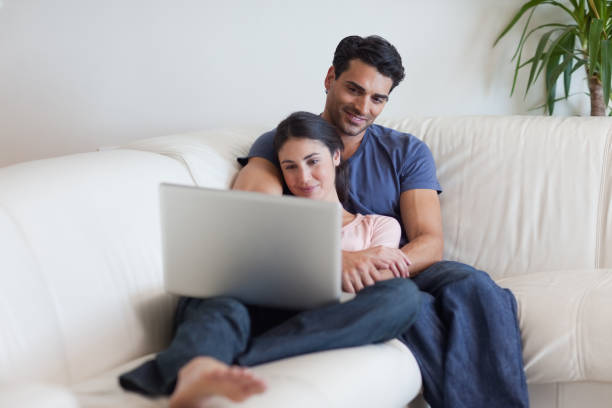 istock Couple watching a movie while eating popcorn 827025686
