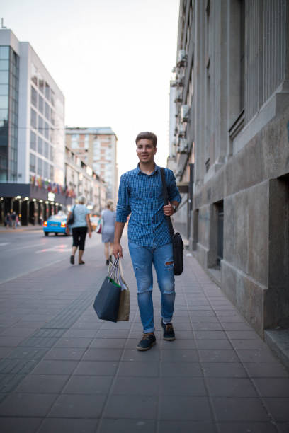 istock Young handsome guy enjoys in shopping 827026542