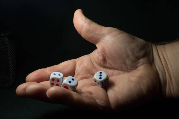 istock dice in hand in black background 827029004