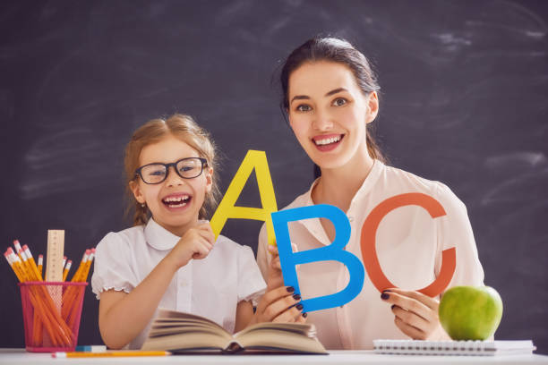 мать и дочь учатся писать - reading and writing classroom alphabet learning стоковые фото и изображения
