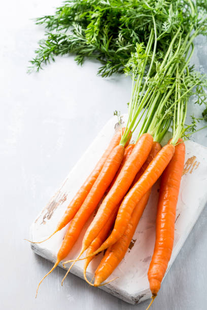 istock Fresh carrots on wooden board 827048124
