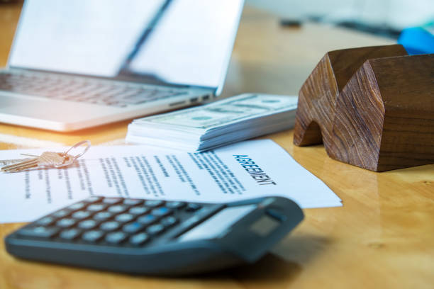 istock Document agreement, model house with dollar bill and calculator. 827050364