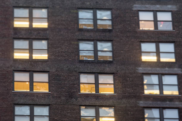 istock City apartment windows at night with lights for privacy concept. 827058216