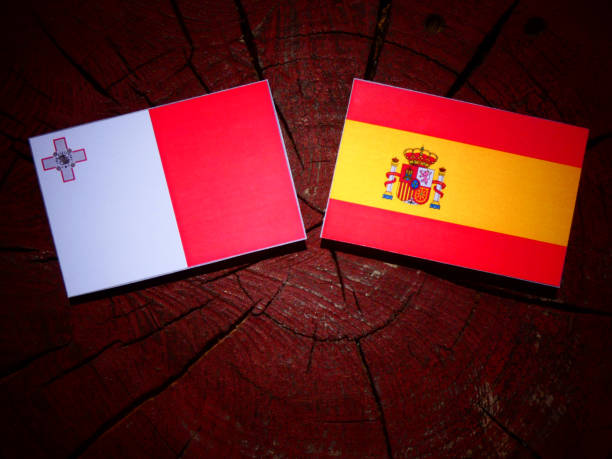 istock Maltese flag with Spanish flag on a tree stump isolated 827060162