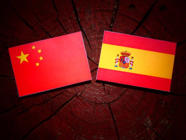 Chinese flag with Spanish flag on a tree stump isolated stock photo