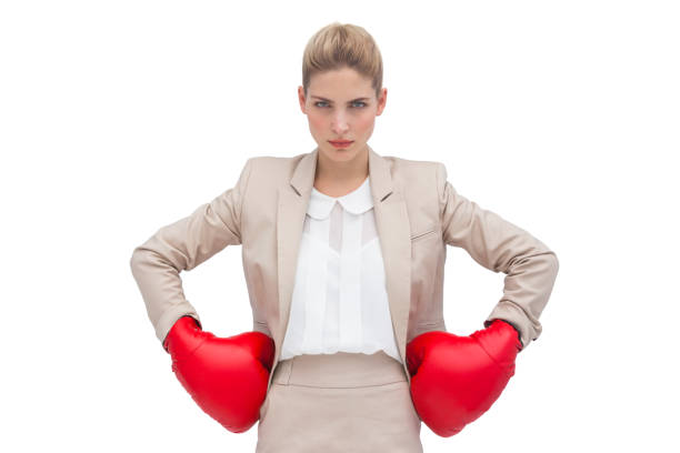 femme d’affaires déterminé avec gants de boxe - women business strength boxing photos et images de collection