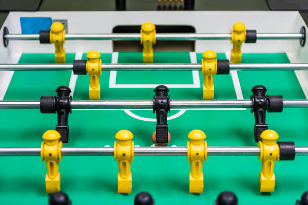 istock Closeup of foosball table with figures and ball rolling 827071934